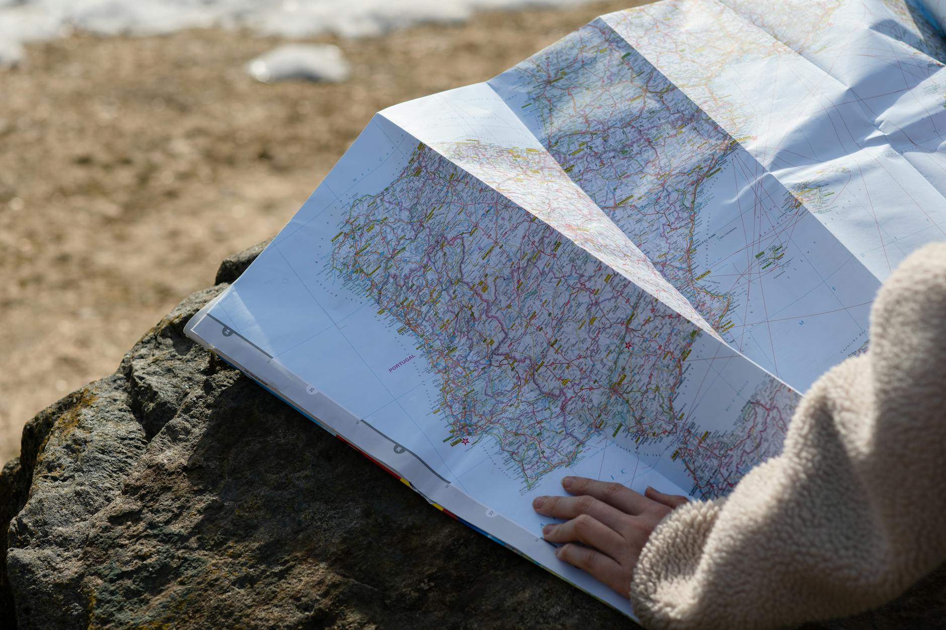 Traveler planning route with laptop and map